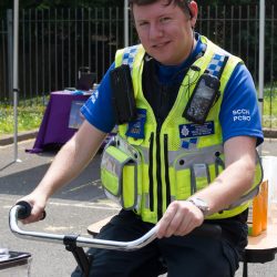 Photo of a police officer riding a bike at a community event